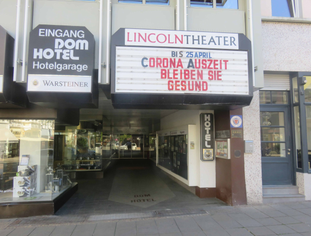 Außenansicht des Lincoln Theaters in Berlin, Deutschland, mit Glasfenstern und -türen, einem Schild und einem belebten Inneren