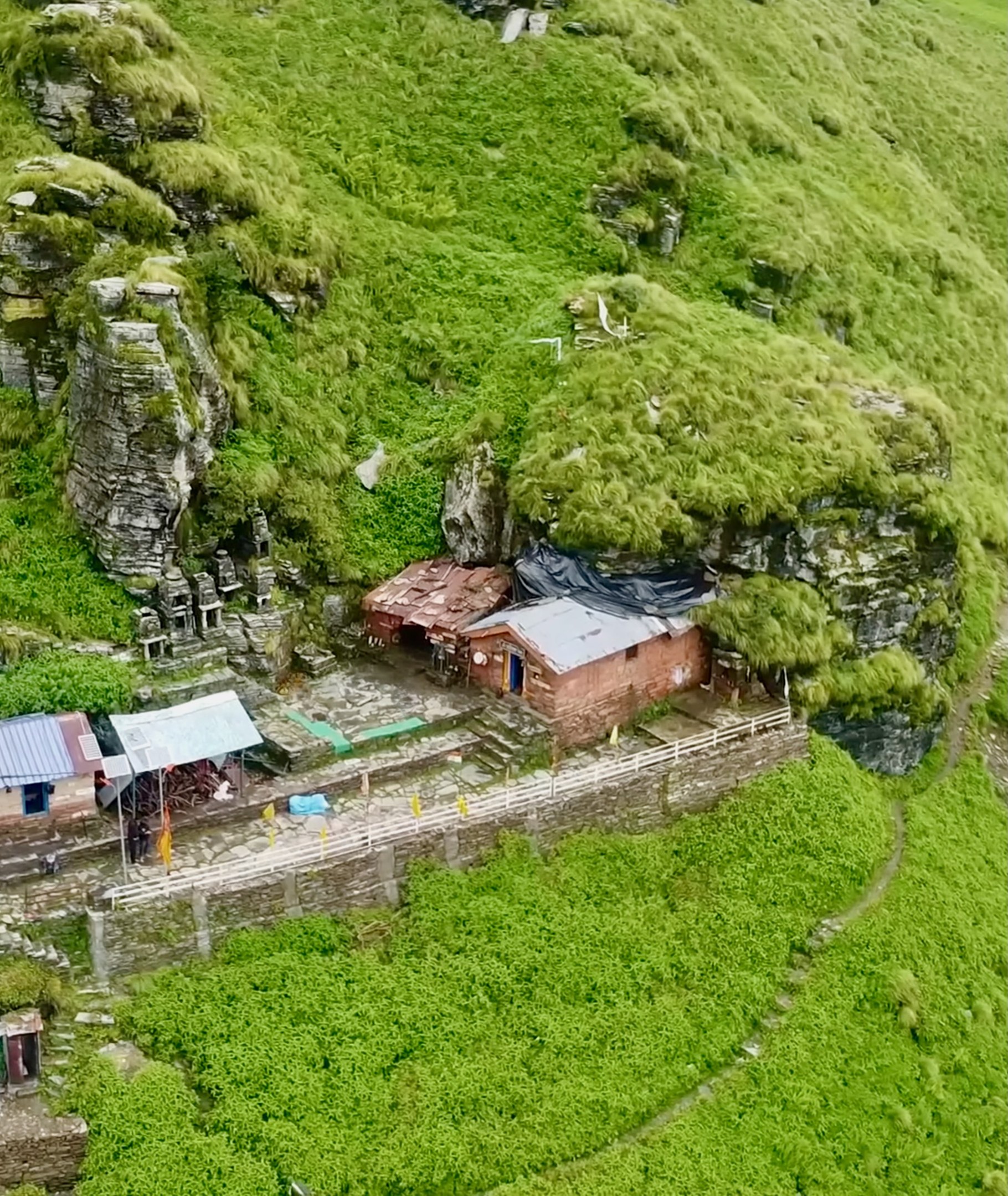 Aerial view of a small village surrounded by greenery with scattered houses and text at the bottom.