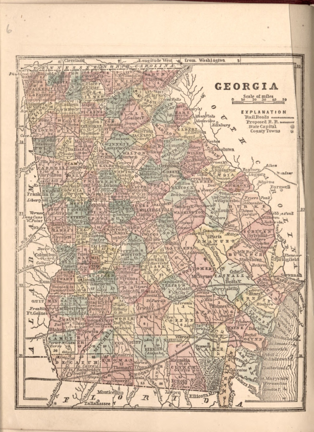 An old book featuring a detailed map of Georgia, including counties and cities, with accompanying text.
