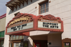 Das Paramount Theatre in Sacramento, Kalifornien, ein Gebäude mit Glasfenstern und -türen und einem Schild mit der Aufschrift "Support the Arts", mit dem Himmel im Hintergrund.