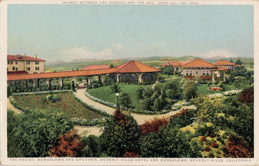 Old postcard of the Beverly Hills Hotel and Bungalows in Beverly Hills, California, showing buildings, trees, plants, flowers, grass, a walkway, light poles, hills, and a sky with text at the top and bottom.
