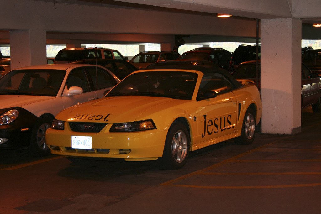 Ein vollbesetzter Parkplatz mit zahlreichen Autos vor einem Gebäude.