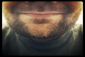 Ein Mann mit Bart in schwarzem Hemd.