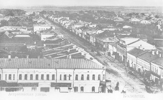 Altes Schwarz-Weiß-Foto einer Stadtstraße mit Gebäuden, Bäumen und Menschen, beschriftet mit "Krasnoyarsk, die Hauptstadt von Russland" unten.