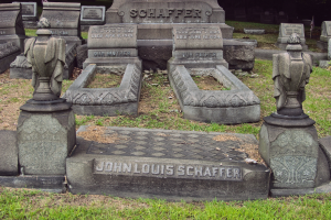 Ein Friedhof mit zahlreichen Grabsteinen, einige mit "John Louis Schaffer" beschriftet, umgeben von Gras und Bäumen.
