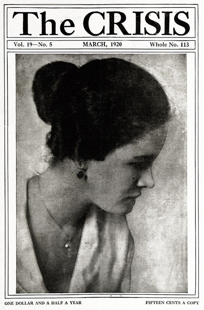 Schwarzes und weißes Porträt einer Frau auf dem Cover von 'The Crisis'-Magazin, trägt ein weißes Kleid mit einem gemusterten Schultertuch, Haare zurückgebunden, Augen zur Seite gewandt, Lippen leicht geöffnet.