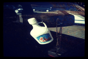 Ein Auto steht auf einer Straße mit einer Kette und einer Flasche in der Nähe.