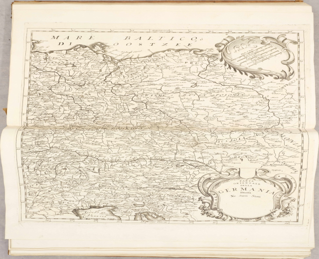 Ein altes Buch mit einer detaillierten Karte von Deutschlands Regionen auf dem Cover, begleitet von erklärendem Text.