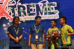 Eine Gruppe von Menschen, die ID-Karten tragen und vor einem Plakat stehen.
