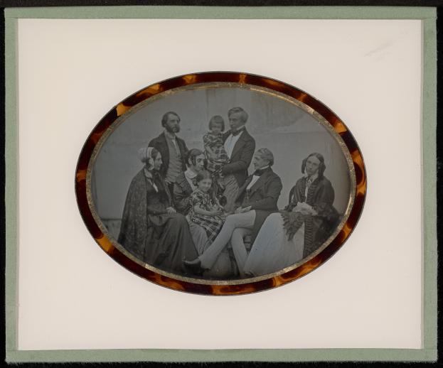 Ein Schwarz-Weiß-Foto einer Familie in formeller Kleidung, gerahmt und posiert für ein Bild.