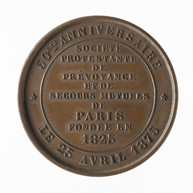 Eine Bronzemedaille mit "50. aniversario" eingraviert vor einem weißen Hintergrund.