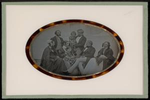 Ein Schwarz-Weiß-Foto einer Familie in formeller Kleidung, gerahmt und posiert für ein Bild.