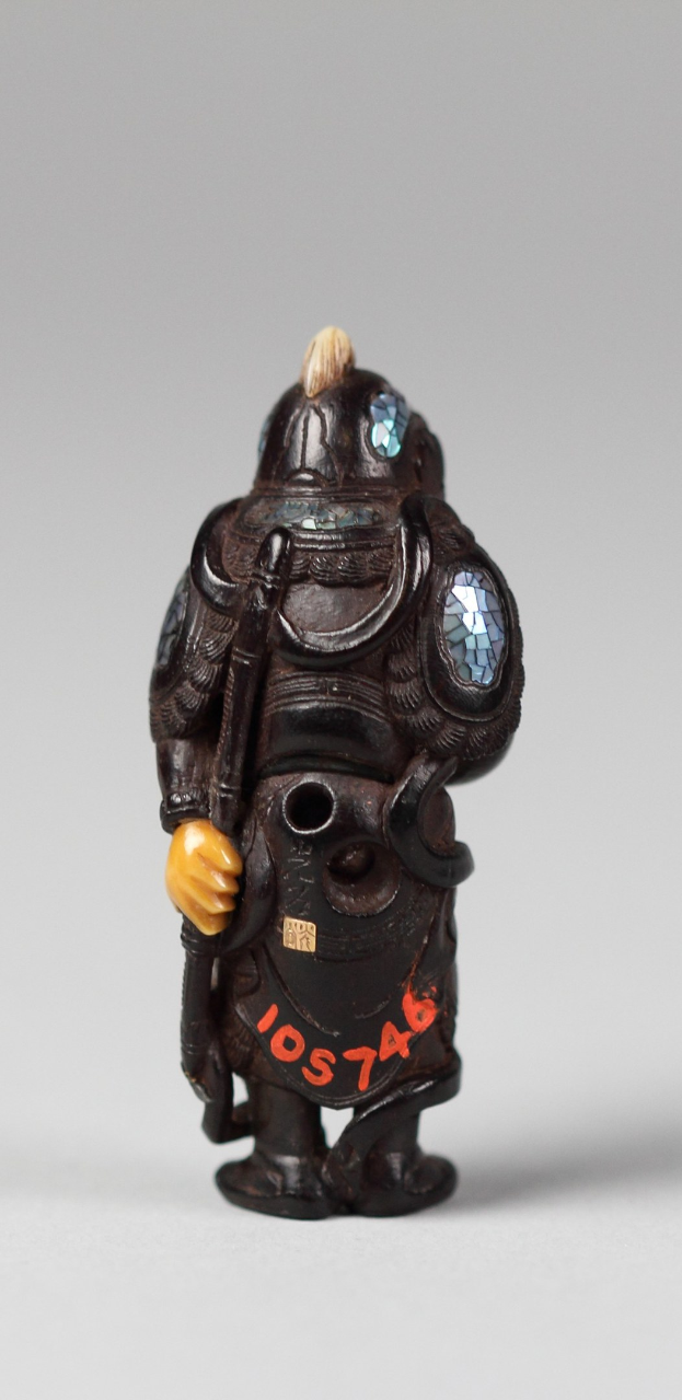 Kleine Figur eines Mannes in schwarzer Rüstung mit Helm, detailliertes Spielzeugdesign auf einem weißen Hintergrund.