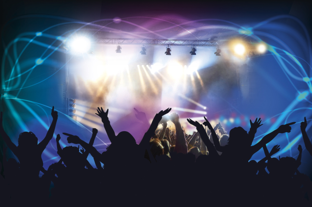 Begeisterte Menge auf einem Konzert mit erhobenen Händen, beleuchtet von farbigen Truss-Lichtern, die eine Bewegung und Energie vermitteln.