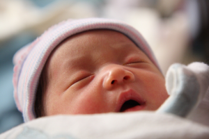 Ein schlafendes Kind im Vordergrund mit einem unscharfen Hintergrund.