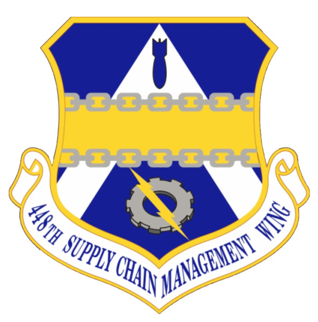 Logo des 48. Versorgungsgeschwader mit einem blauen Schild, einem weißen Stern und einem weißen Banner mit der Aufschrift "Versorgungsgeschwader" in blau, alles von einem weißen Rand und schwarzer Schrift umrandet.