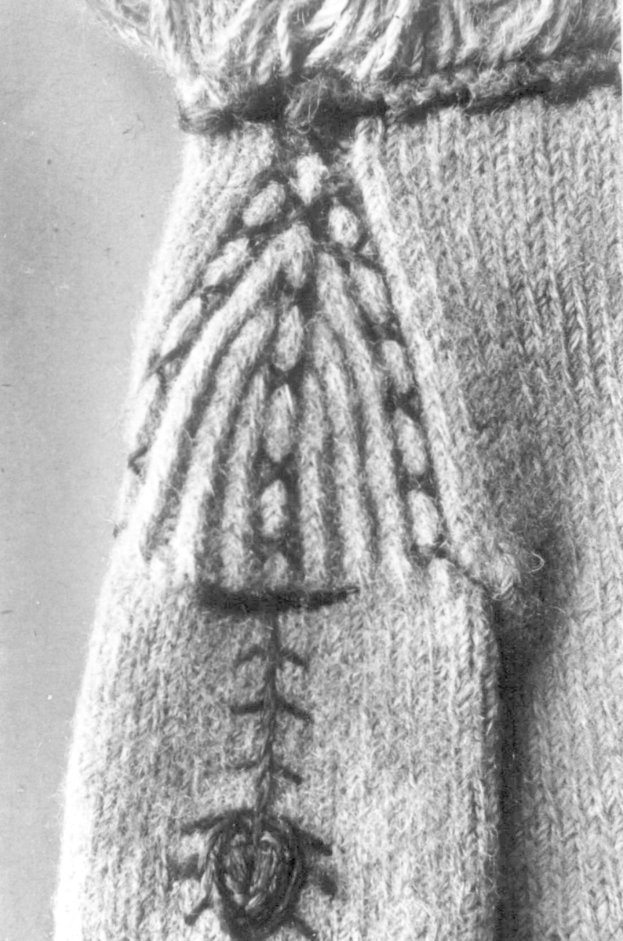 Ein Schwarz-Weiß-Foto eines wollenen Pullovers mit einem komplexen, detaillierten Muster in verschiedenen Formen und Farben.