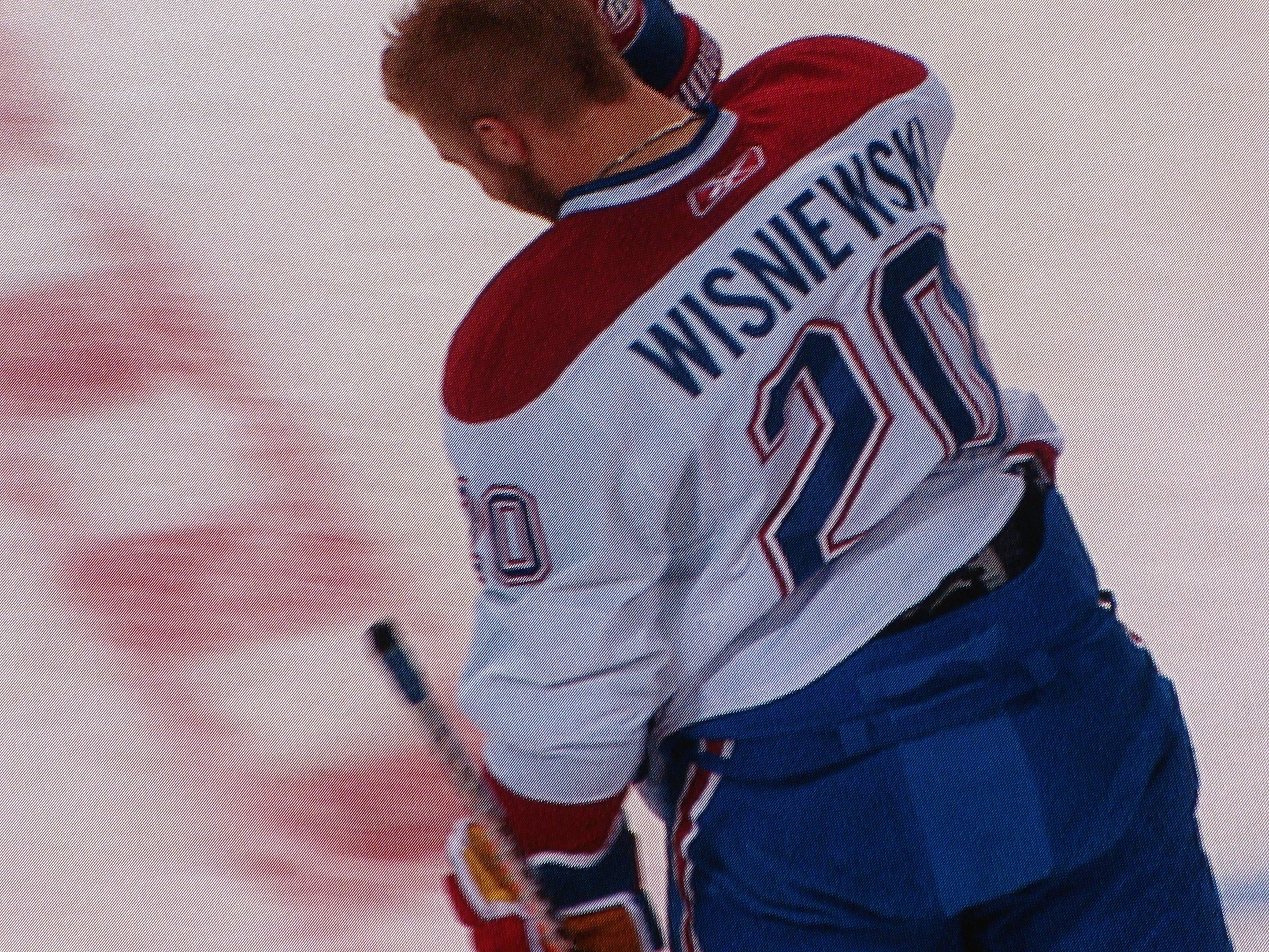 Professioneller Eishockeyspieler mit einem 'Wisniewski'-Trikot, der entschlossen auf dem Eis steht und einen Hockey-Schläger hält.