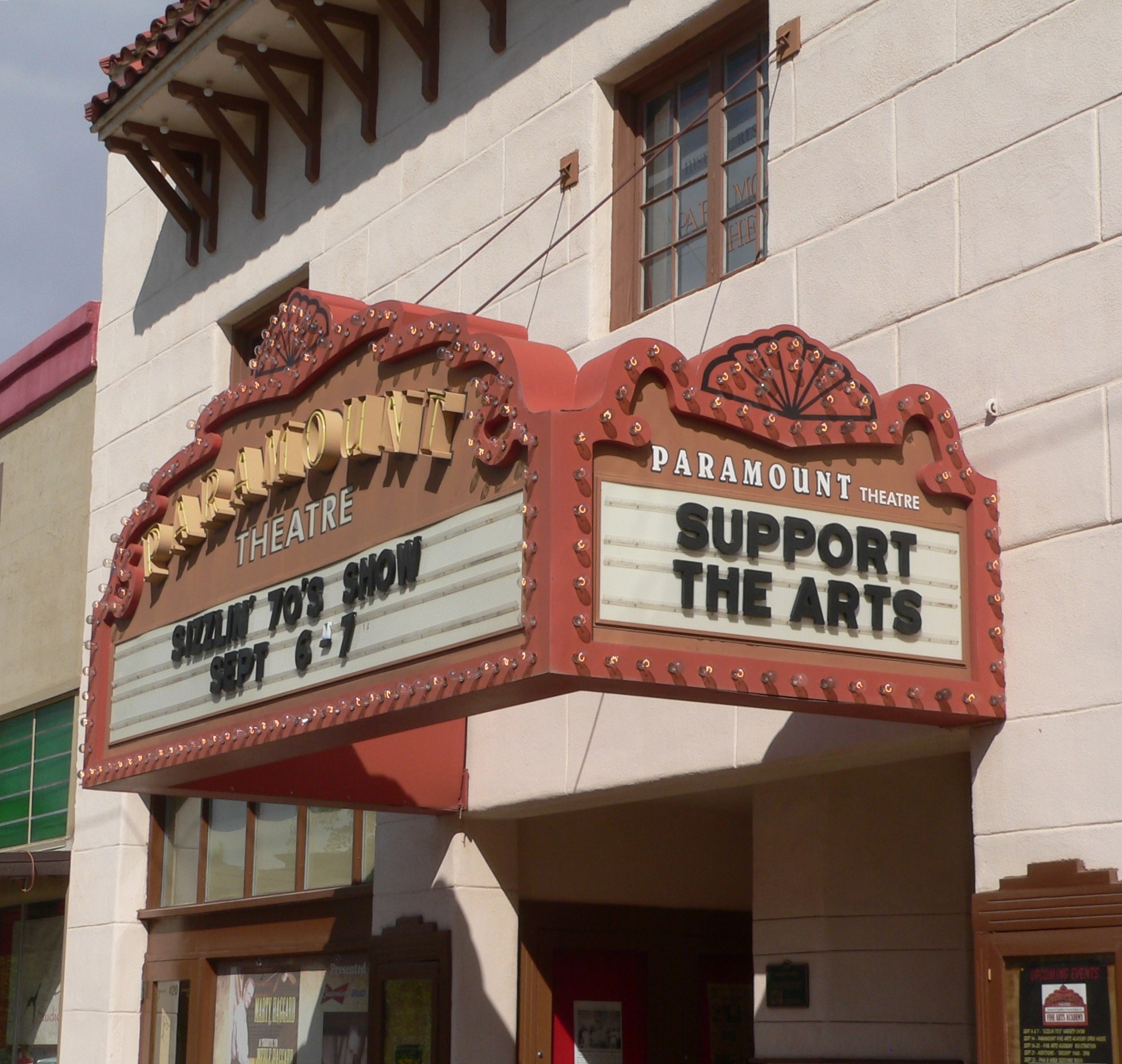 Außenansicht des Paramount Theatre in Sacramento, Kalifornien, mit Glasfenstern und -türen und einer 'Support the Arts'-Schrifttafel über dem Eingang, vor einem sichtbaren Himmel.