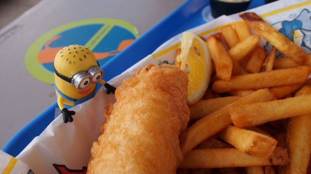 Ein Teller mit Essen und einem Spielzeug auf der linken Seite und anderen Gegenständen im Hintergrund.
