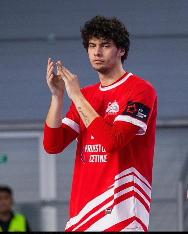 A man in a red and white shirt clapping in the foreground with another person and a wall in the background, text at the bottom reads "Copenhagen futsal club - foto 1".