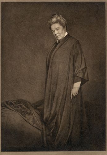 Ein altes Schwarz-Weiß-Foto einer Frau in einer Robe, die vor einem Bett mit einer Decke steht, mit dem Text "Lutheran" unten.