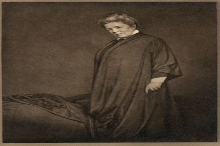 Ein altes Schwarz-Weiß-Foto einer Frau in einer Robe, die vor einem Bett mit einer Decke steht, mit dem Text "Lutheran" unten.