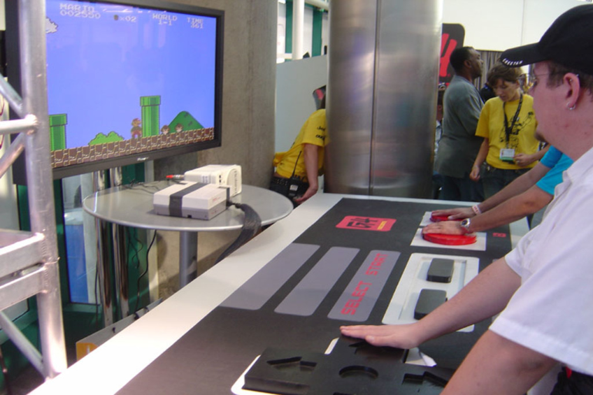 Ein Mann steht neben einem Fernsehbildschirm.