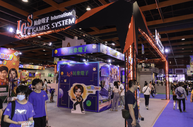 Eine Gruppe von Menschen geht durch einen Convention-Saal auf einer Gaming-Messe in China, einige tragen Taschen und halten Gegenstände, mit Display-Boards, Deckenleuchten und Teppichboden.