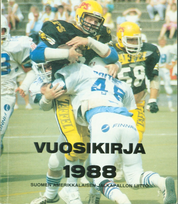 Eine Gruppe von Menschen in Sportbekleidung und Helmen, die Fußball auf einem Feld spielen, mit einigen Personen, die im Hintergrund auf einer Treppe sitzen; unten steht der Text 'Vuosikirja 1988 - Suomen Amerikkaisen Jalkapallon Litto'.