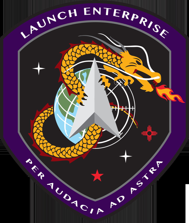 Logo des Space Shuttle Enterprise mit einem furchterregenden Drachen mit ausgebreiteten Flügeln und erhobenem Kopf, einer tiefblauen Weltkugel mit weißer Umrandung und schwarzem, fetten Text darunter, der "Space Shuttle Enterprise" lautet.