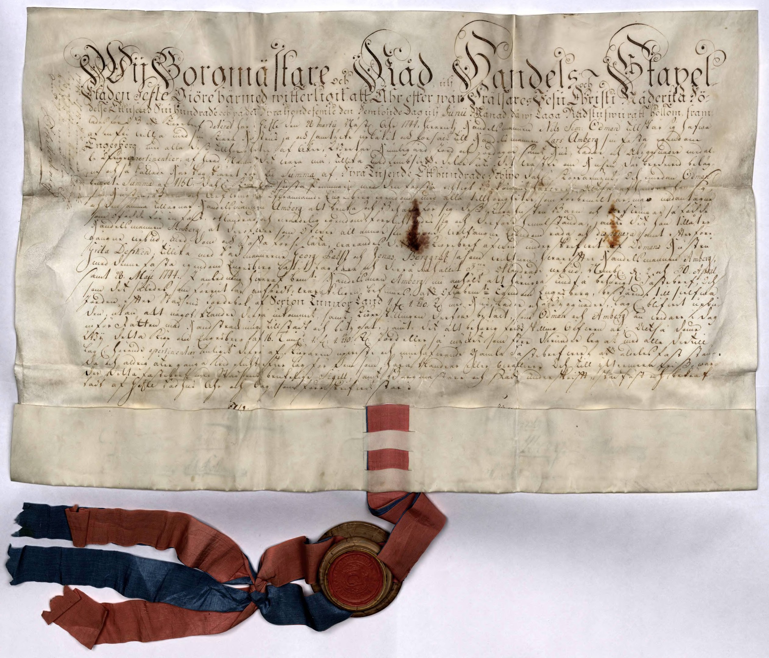 Altes Dokument mit einer roten, weißen und blauen Schleife, auf der Text zu erkennen ist.